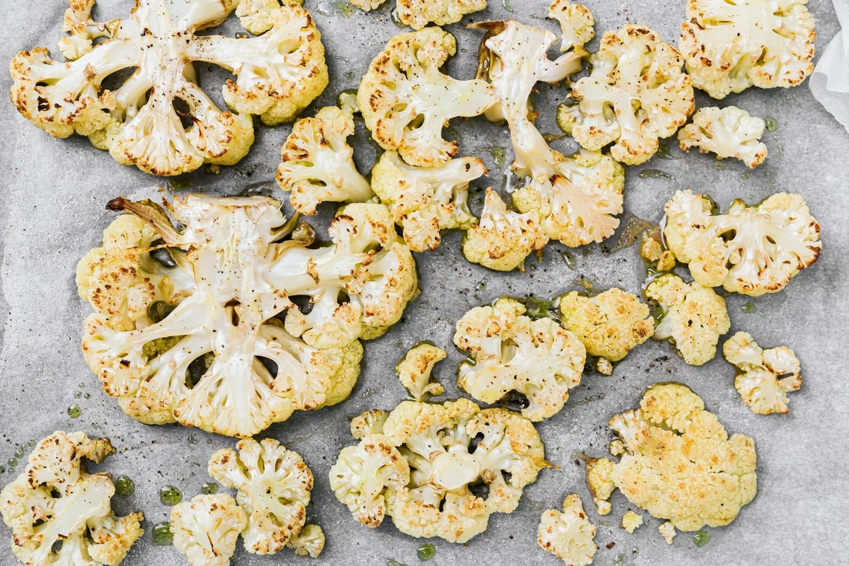 Bouquets de chou-fleur rôtis et dorés sur une plaque de cuisson, vus de dessus
