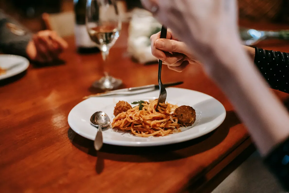 Assiette de pâtes faites maison sur une table en bois, ambiance chaleureuse du soir