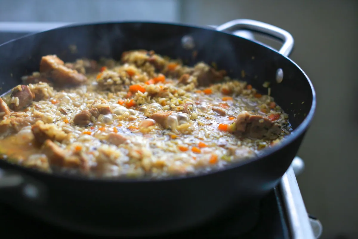 Grande casserole contenant un plat complet de riz et légumes, cuisson one pot