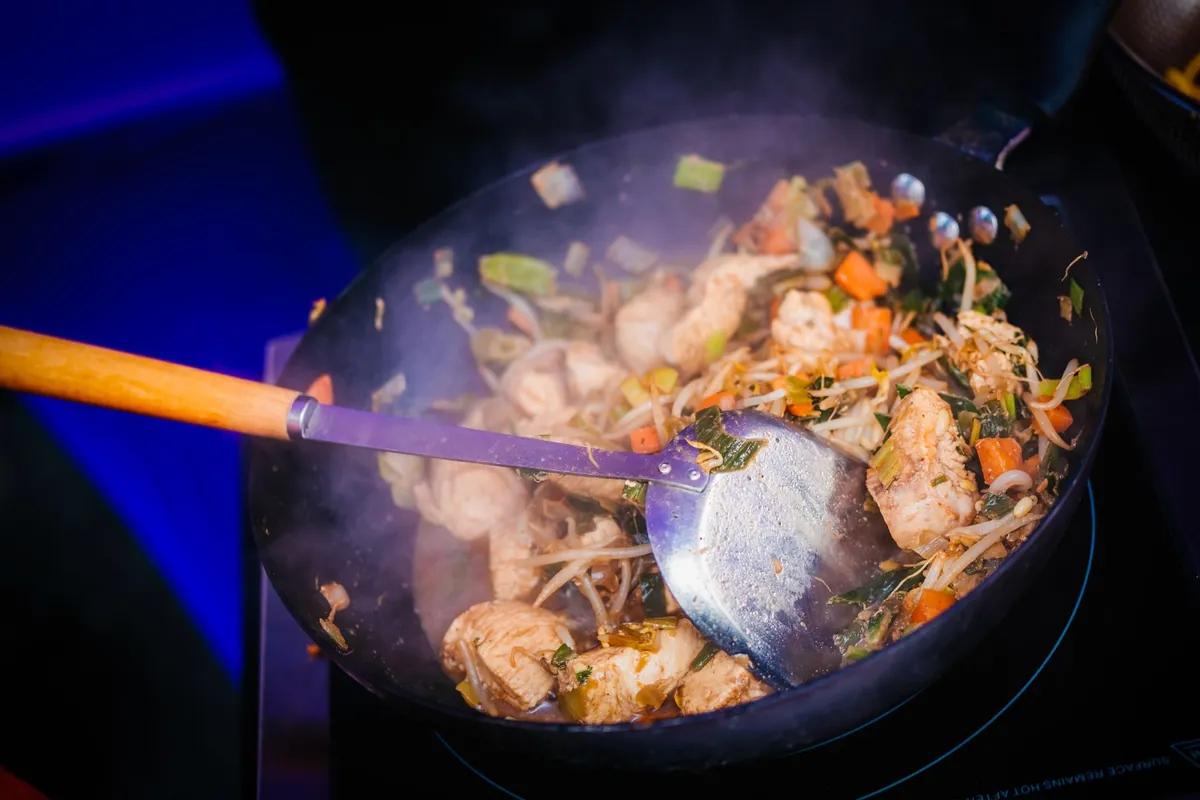 Poêlée colorée de légumes qui grésille sur une cuisinière à gaz