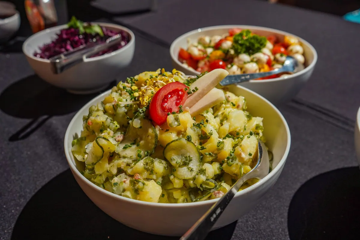 Kartoffelsalat allemand avec pommes de terre, oignon rouge et ciboulette dans un saladier