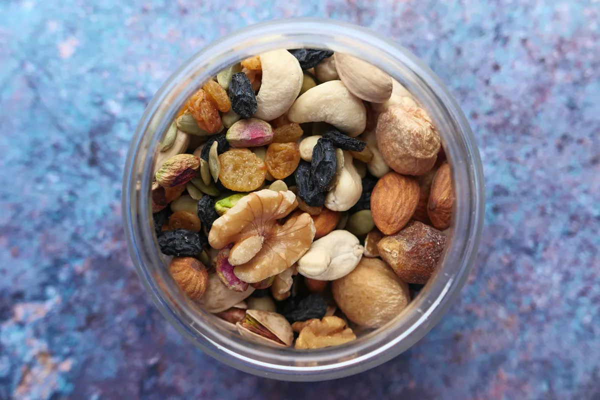 Mélange montagnard maison avec noix, fruits secs et pépites de chocolat dans un bocal