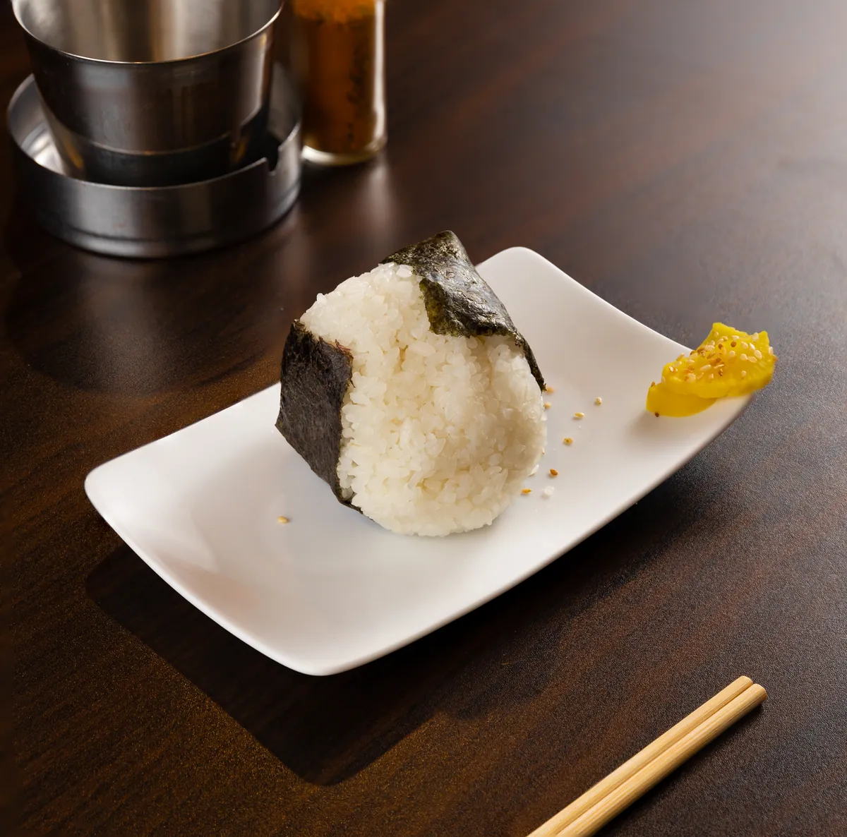 Onigiri triangulaires enveloppés de nori posés sur une assiette