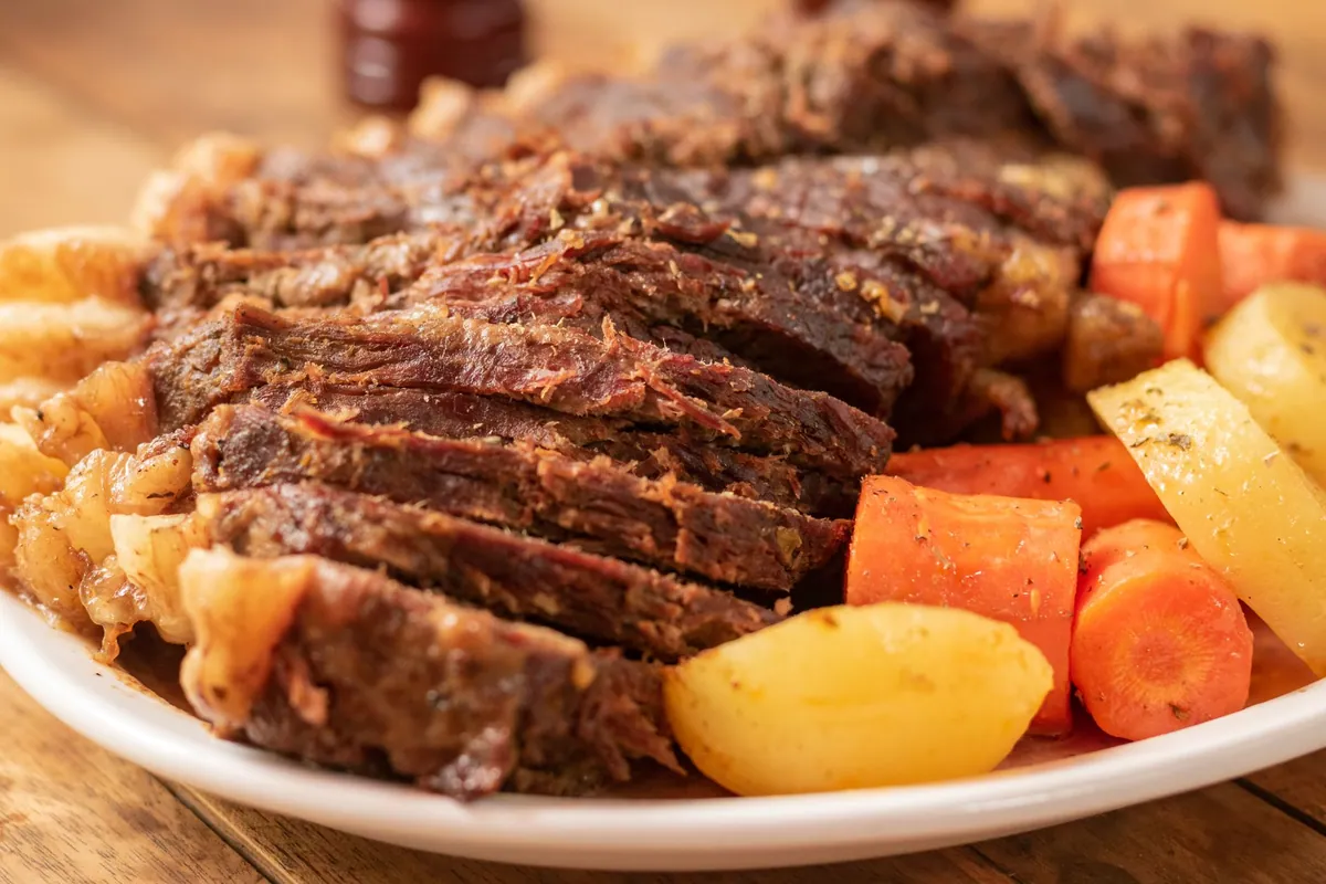 Sauerbraten tranché nappé de sauce brune dans une assiette